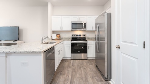 open floorplan with vinyl flooring, living room, kitchen and sliding glass door