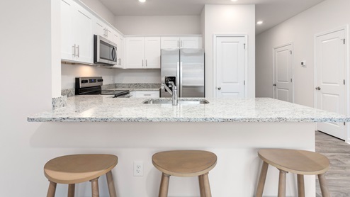 open floorplan with vinyl flooring, living room, kitchen and sliding glass door