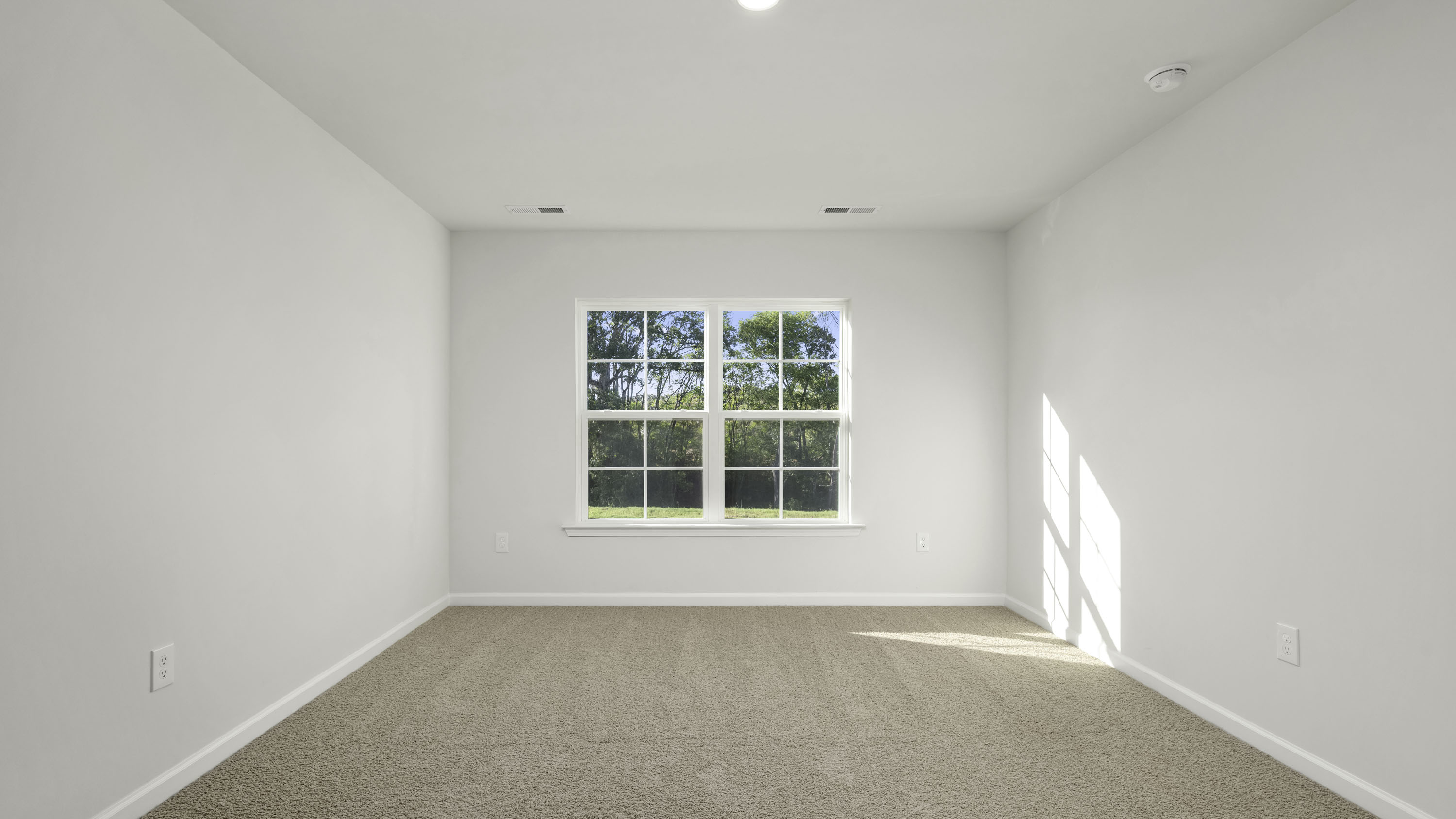 Neutral-toned wall-to-wall carpeting, crisp neutral wall paint, multi-pane window, and recessed ceiling lighting