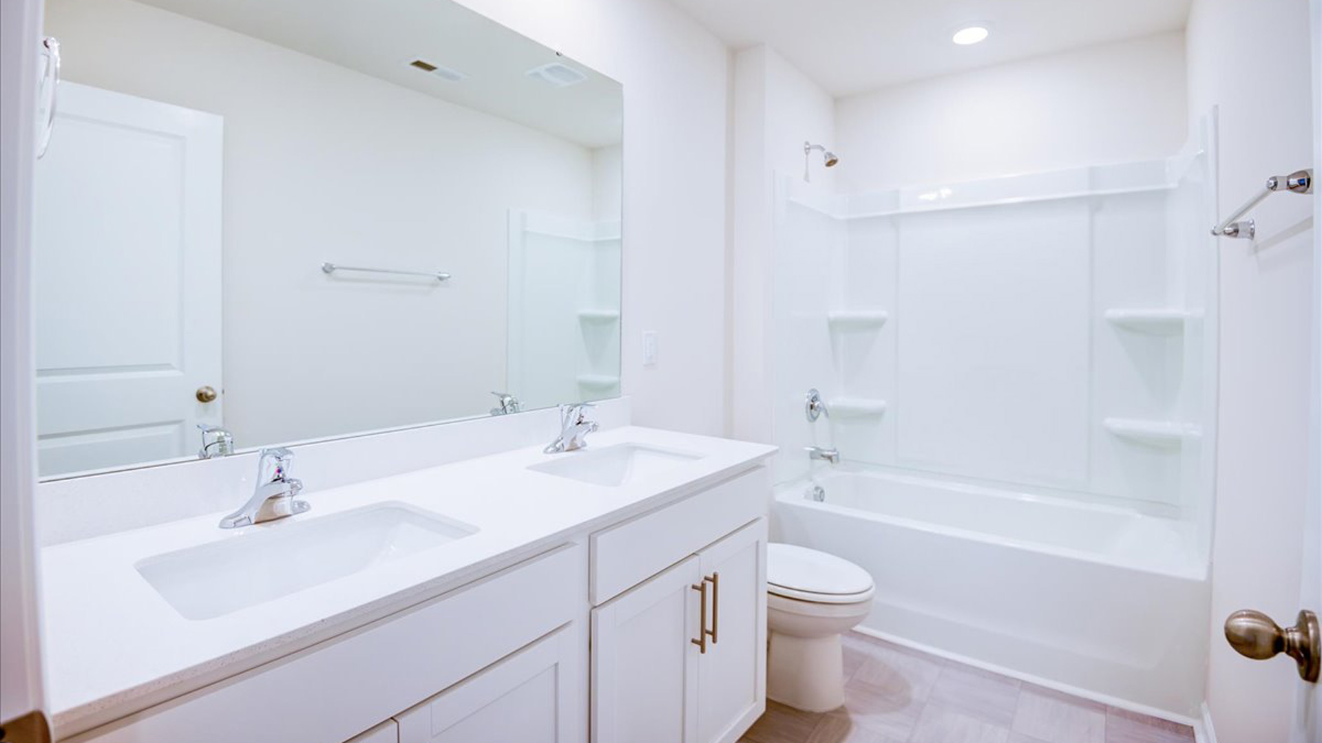 secondary bathroom with dual sinks and tub shower combo