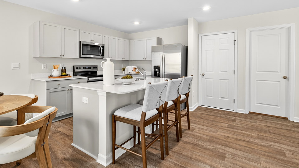 kitchen with gray cabinets stainless steel appliances and quartz countertops