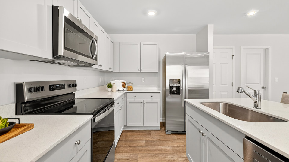 kitchen with gray cabinets stainless steel appliances and quartz countertops