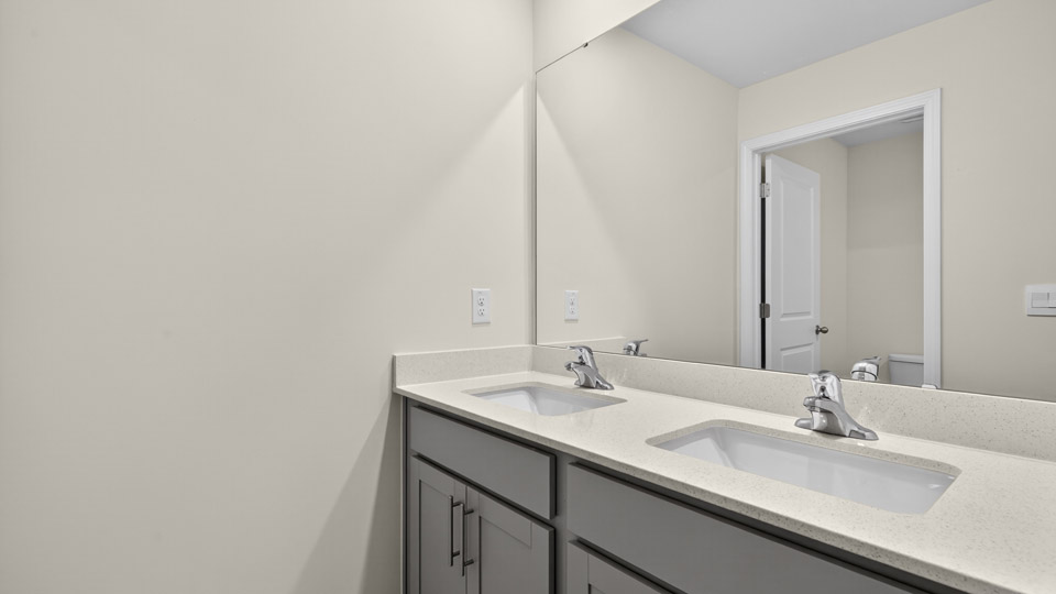 bathroom with gray cabinets and quartz countertops