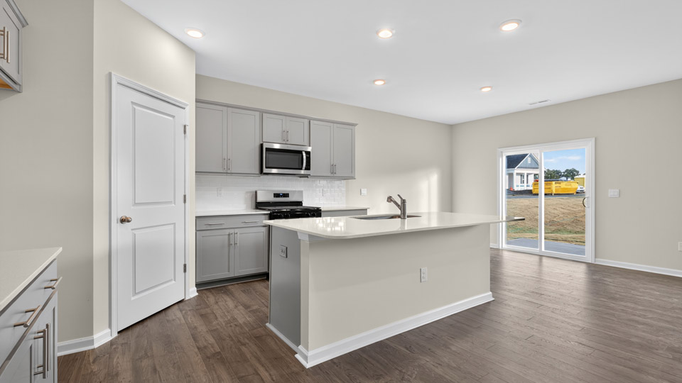 kitchen with gray cabinets, quartz countertops and stainless steel appliances
