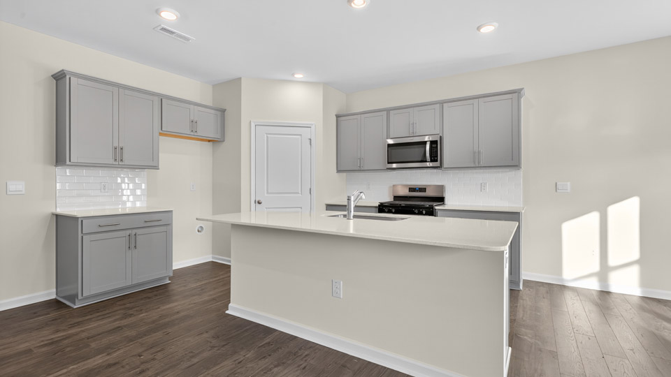 kitchen with gray cabinets, quartz countertops and stainless steel appliances