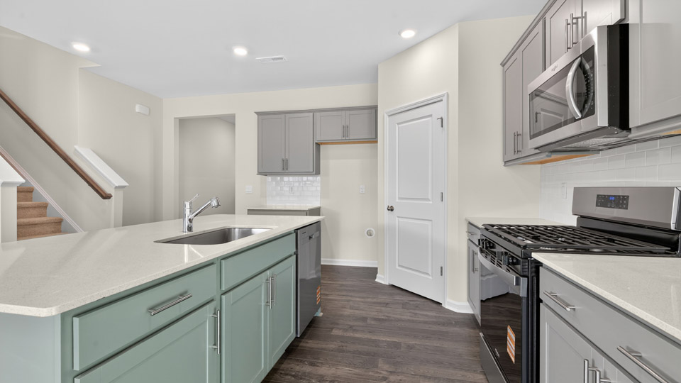 kitchen with gray cabinets, quartz countertops and stainless steel appliances