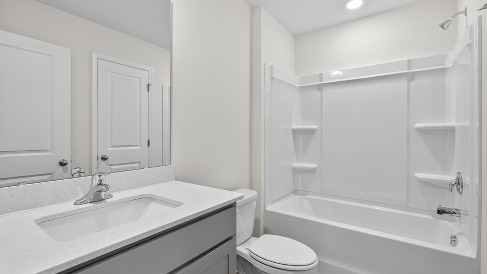 bathroom with tub shower combo and quartz countertops