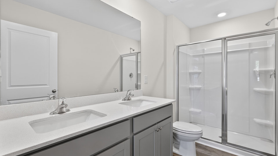 bathroom with quartz countertops and walk-in glass door shower