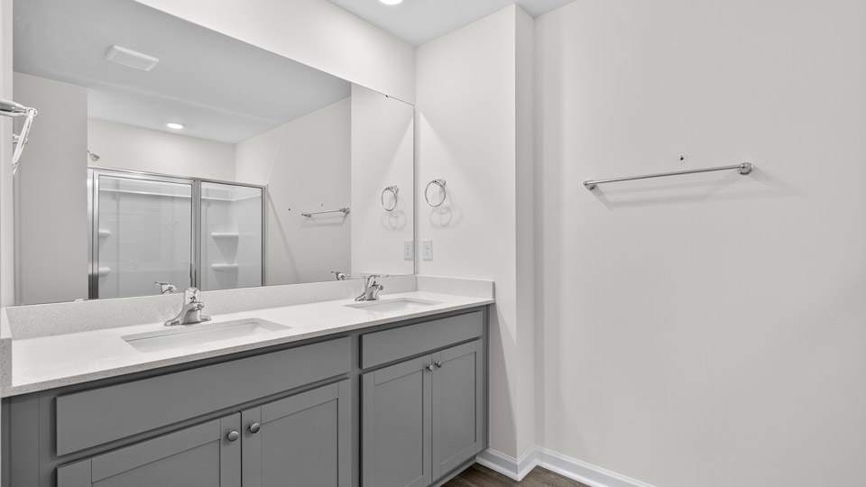 bathroom with gray cabinets dual vanity and quartz countertops