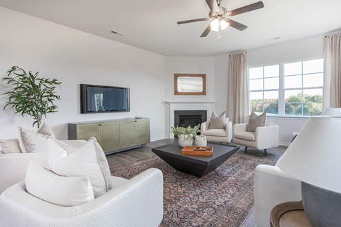 Living area with ample lighting and revwood flooring and gas fireplace