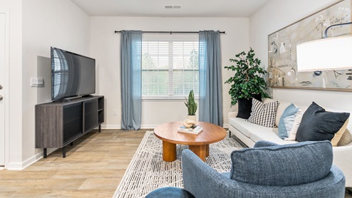 Living area with ample lighting and revwood flooring