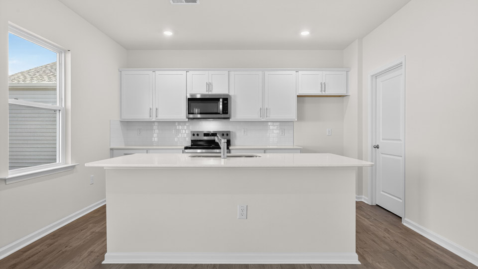 kitchen with stainless steel appliances and white cabinets and quartz countertops