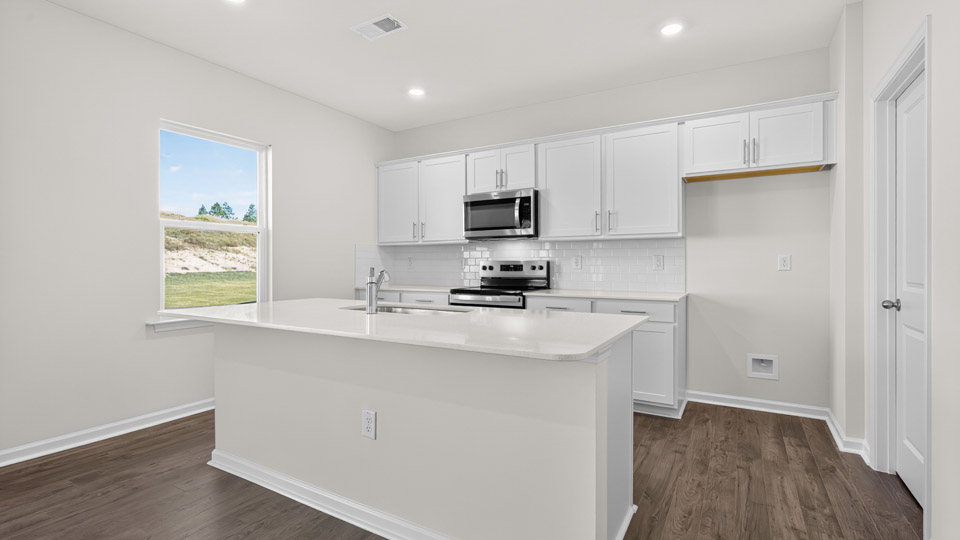 kitchen with stainless steel appliances and white cabinets and quartz countertops
