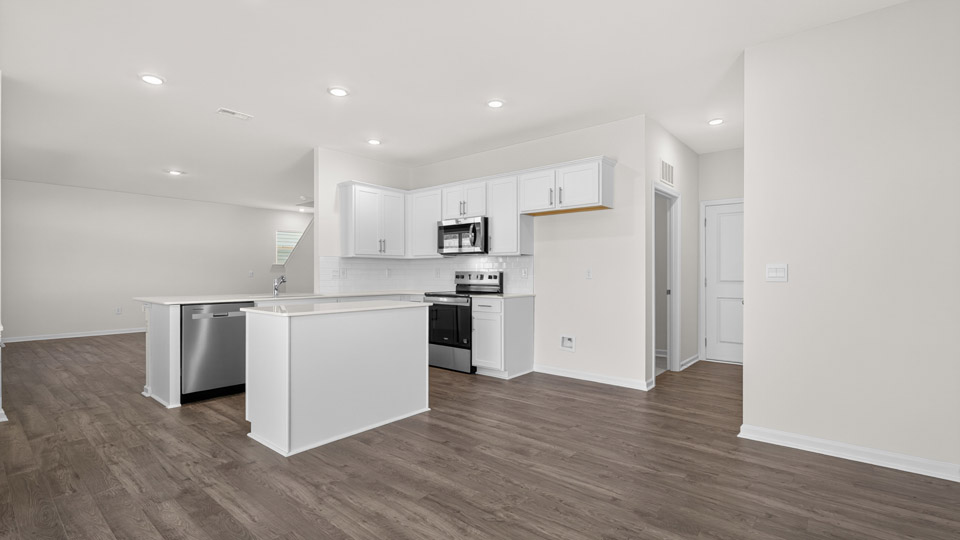 kitchen with white quartz countertops and white cabinets and stainless steel appliances