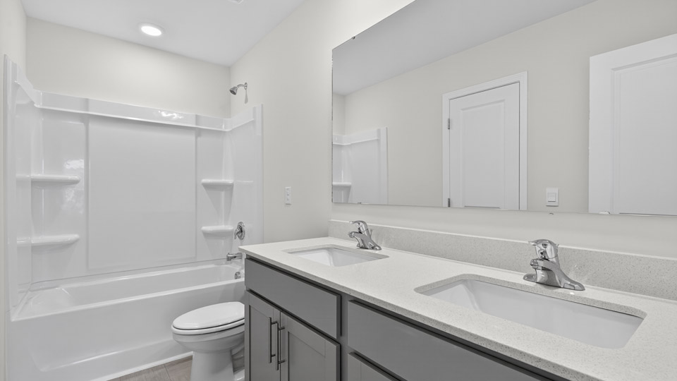 bathroom with gray cabinets and quartz countertops