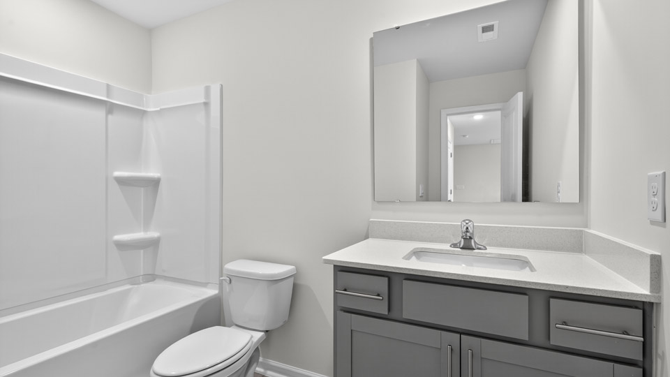 bathroom with gray cabinets and quartz countertops