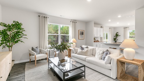 Living area with ample lighting and revwood flooring