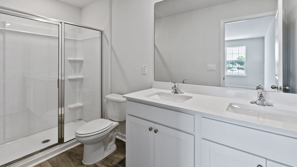 primary bathroom with walk in shower and dual vanity sinks