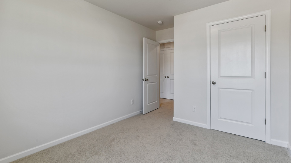 secondary bedroom with window and closet, carpeting