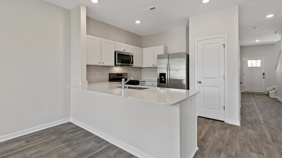 kitchen with quartz counters, kitchen island, pantry, stainless steel appliances