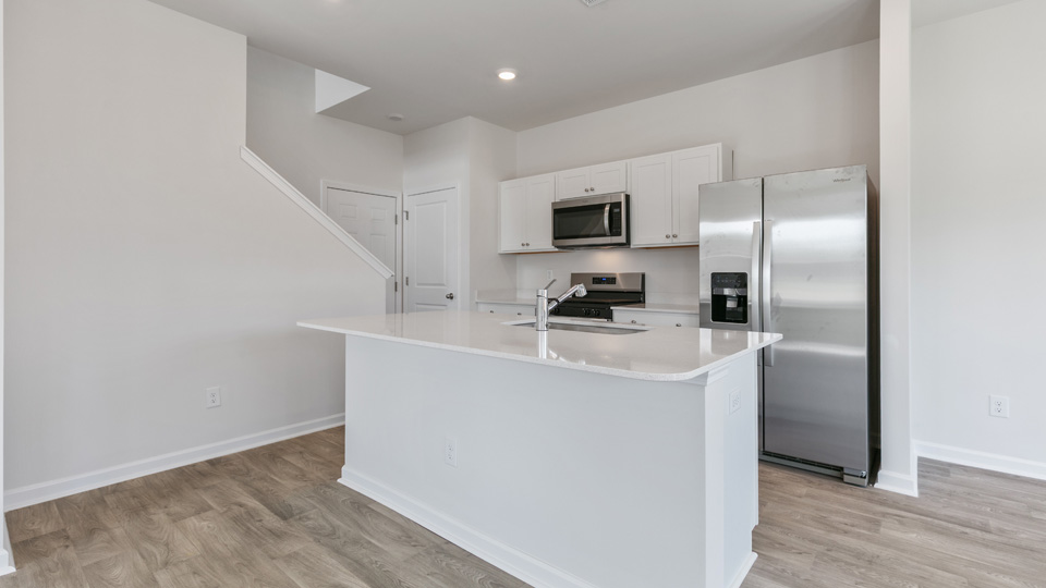 kitchen with quartz counters, kitchen island, pantry, stainless steel appliances