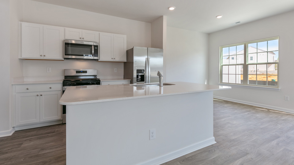 kitchen with quartz counters, kitchen island, pantry, stainless steel appliances