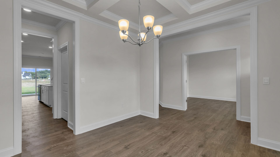 dining room with revwood flooring and coffered ceiling