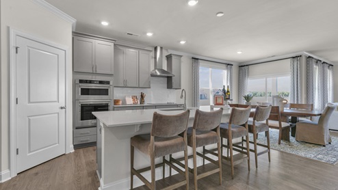 kitchen with quartz counters, kitchen island, pantry, stainless steel appliances