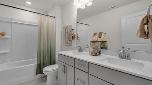 secondary bathroom with shower tub combo and double vanity sink