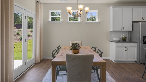 Living and dining area with ample lighting and revwood flooring