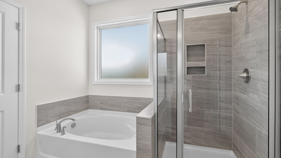 bathroom with separate tub and walkin shower with tile surrong