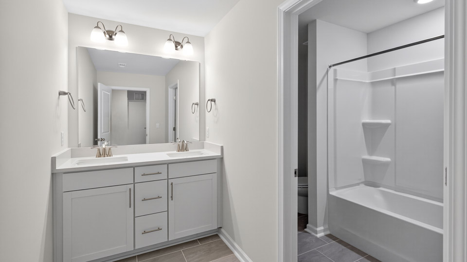 bathroom with white cabinets and quartz countertops