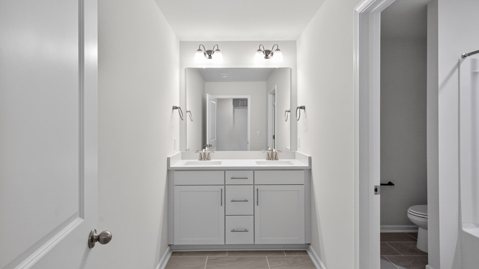 bathroom with white cabinets and quartz countertops
