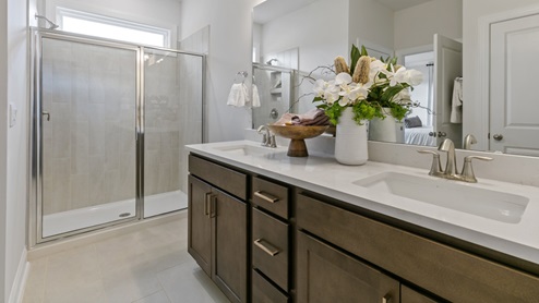 bathroom with white quartz countertops and brown cabinets