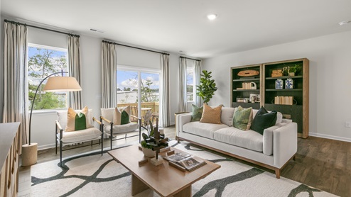 Living area with ample lighting and revwood flooring