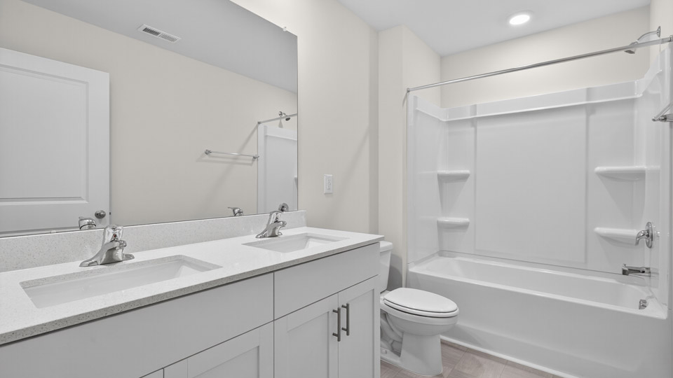 bathroom with white cabinets quartz countertops and tub shower combo