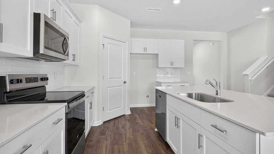 kitchen with island white cabinets quartz countertops and stainless steel appliances