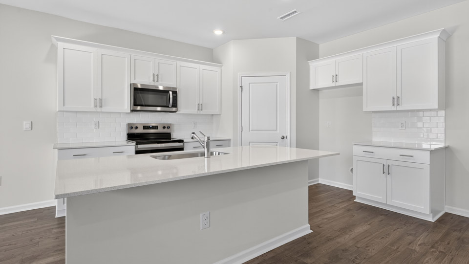 kitchen with island white cabinets quartz countertops and stainless steel appliances