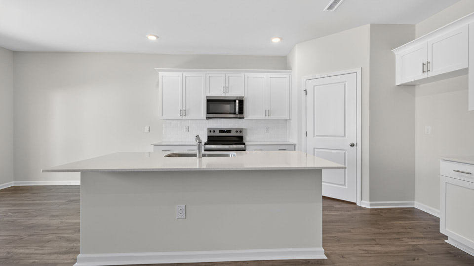 kitchen with island white cabinets quartz countertops and stainless steel appliances