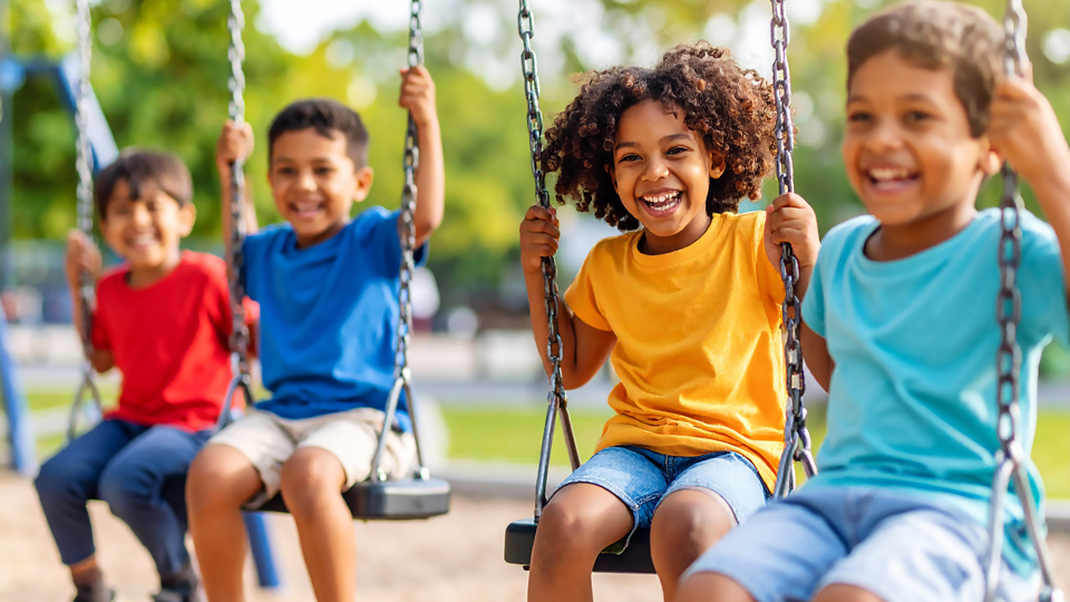 laughing kids swinging on swing set