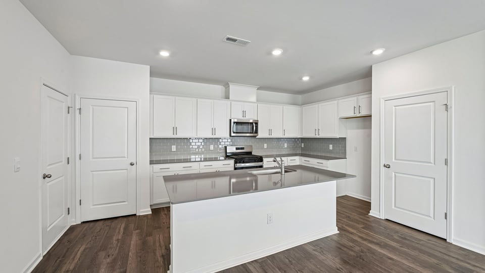 kitchen with white cabinets spacious island and quartz countertops