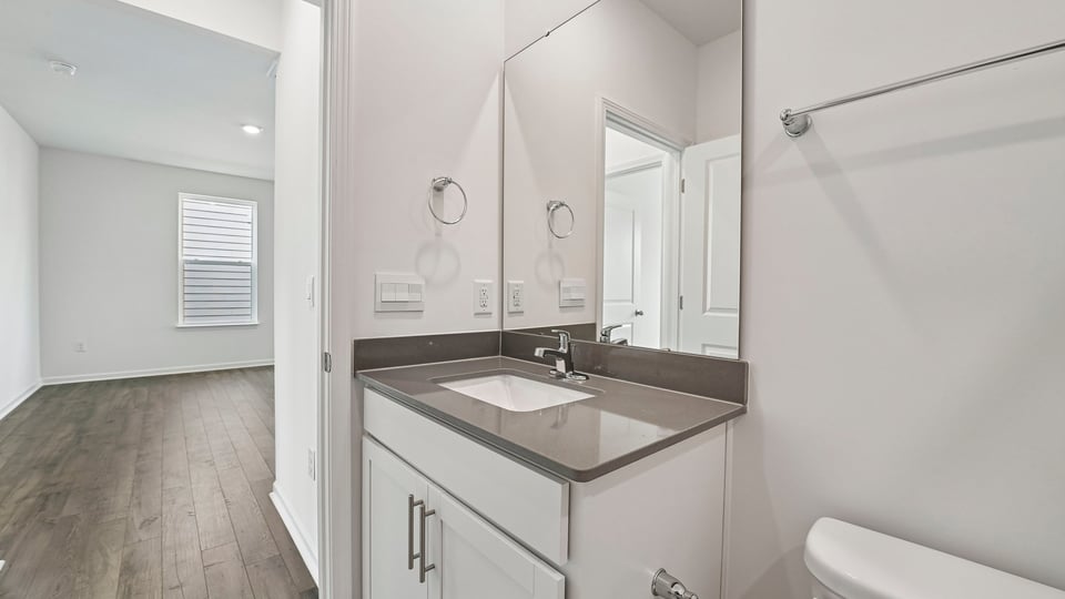 bathroom with quartz countertops and white cabinets