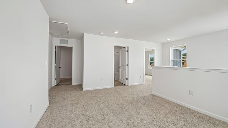 loft area at top of stairs with carpet flooring