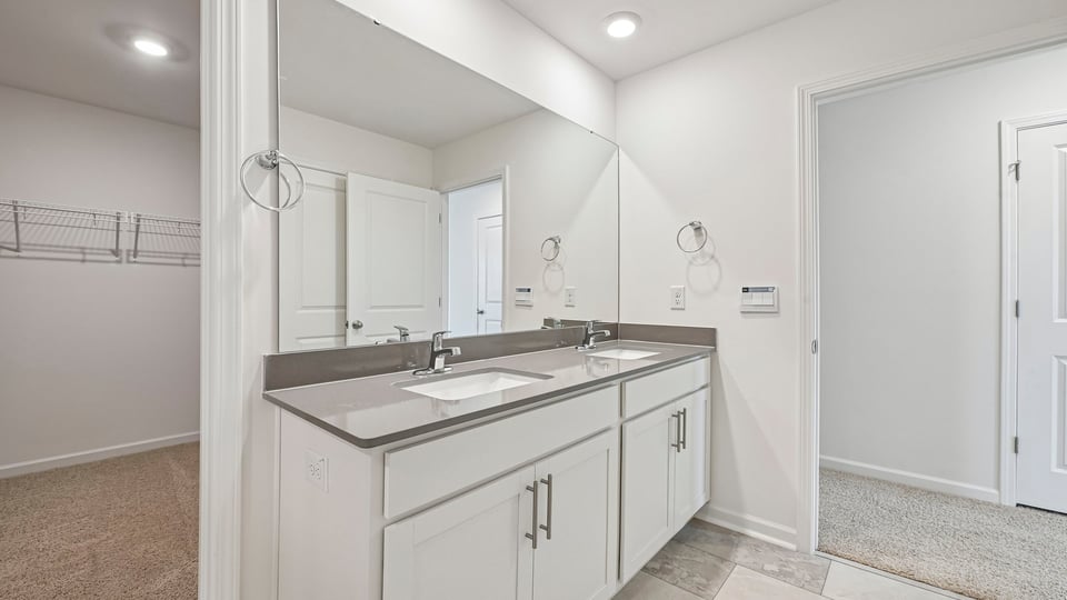 bathroom with dual vanity and quartz countertops