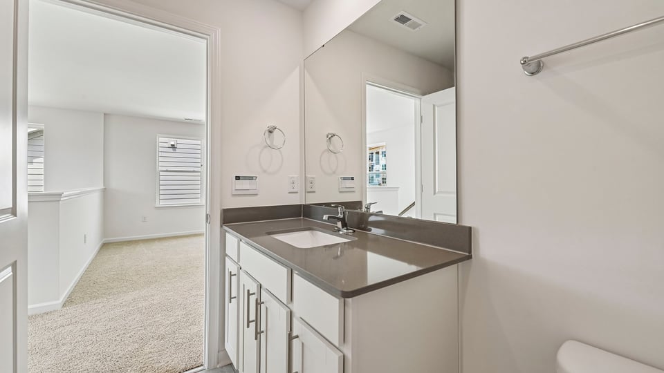 bathroom with quartz countertops and white cabinets