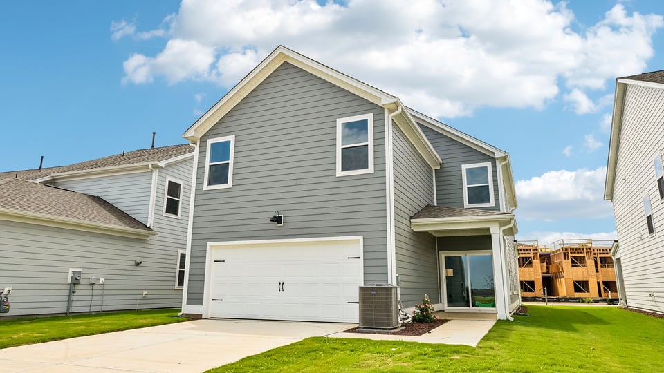 back of home with two car garage and covered patio