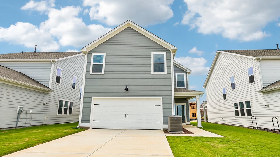 back of home with two car garage and covered patio