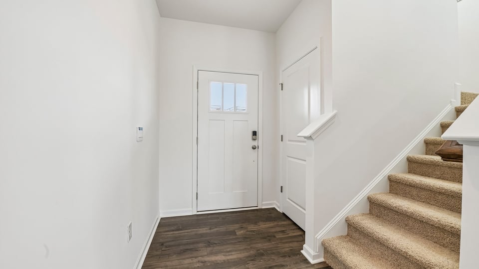foyer entryway with carpeted staircase