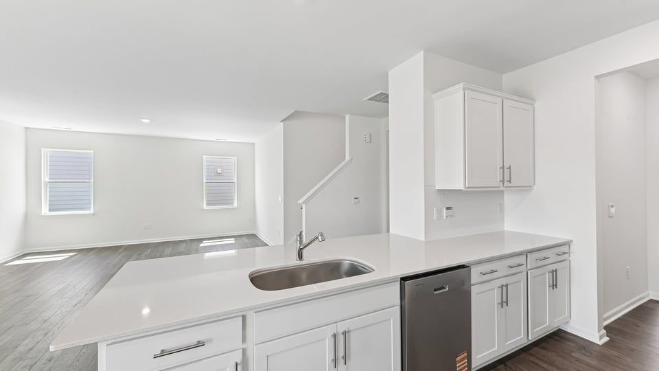 kitchen with quartz counters, kitchen island, pantry, stainless steel appliances