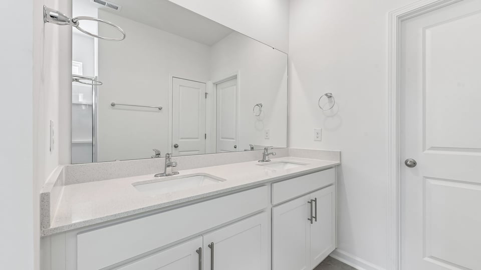 secondary bathroom with walk in shower and single vanity sink